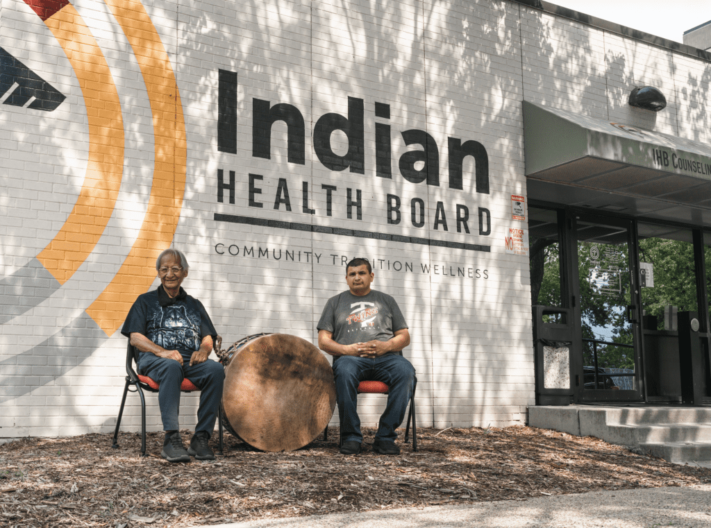 two men sitting in chairs outside of a building