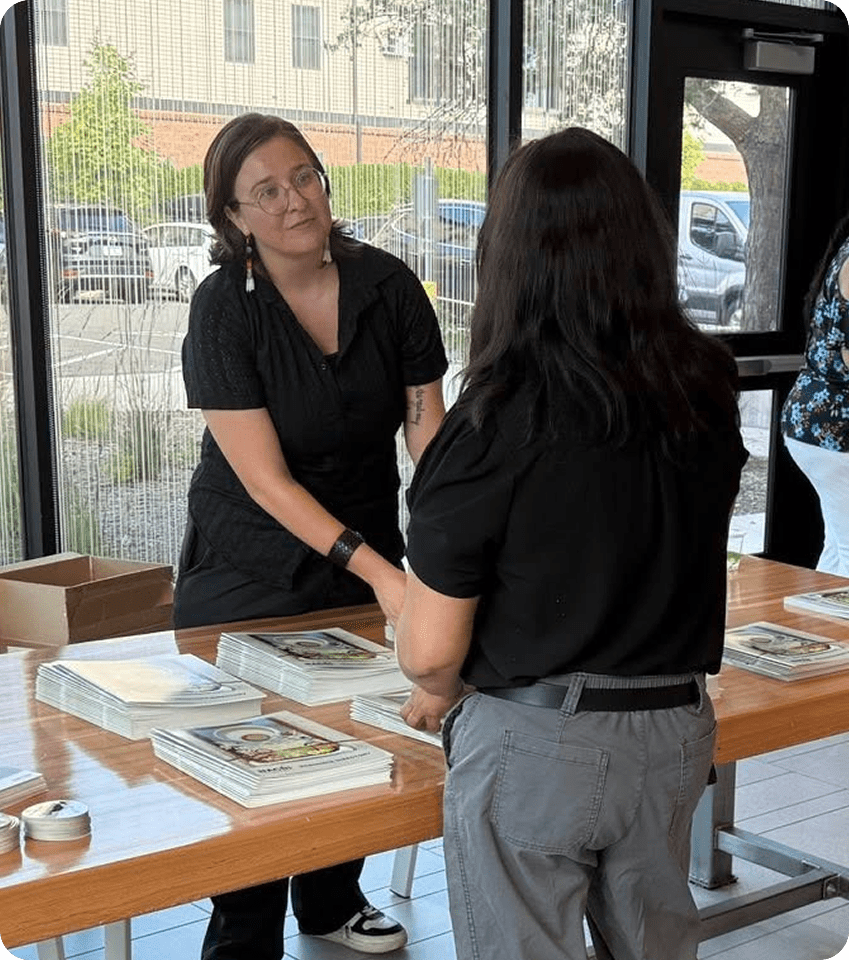a person standing next to a table with books
