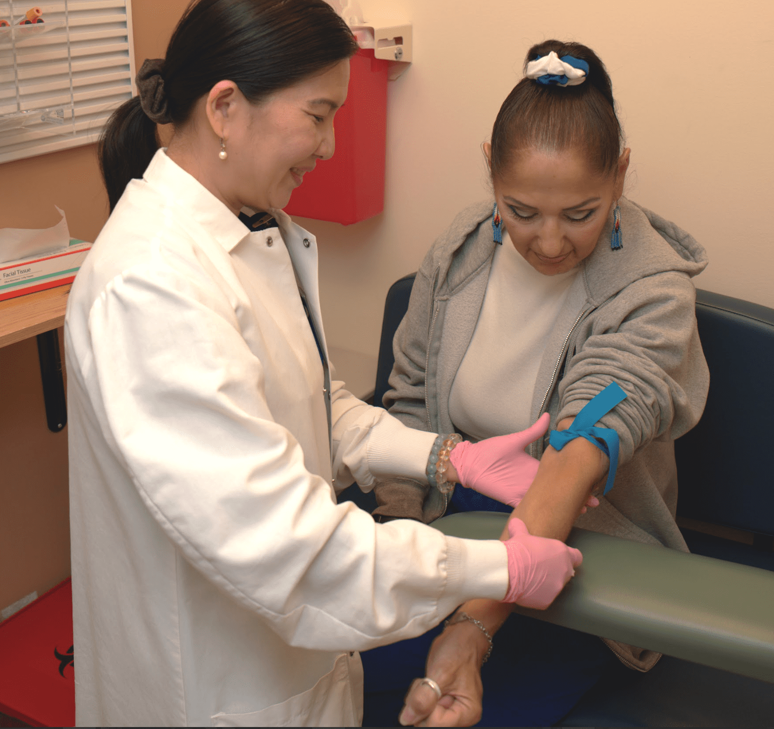 a person in a white coat getting blood sample from a patient