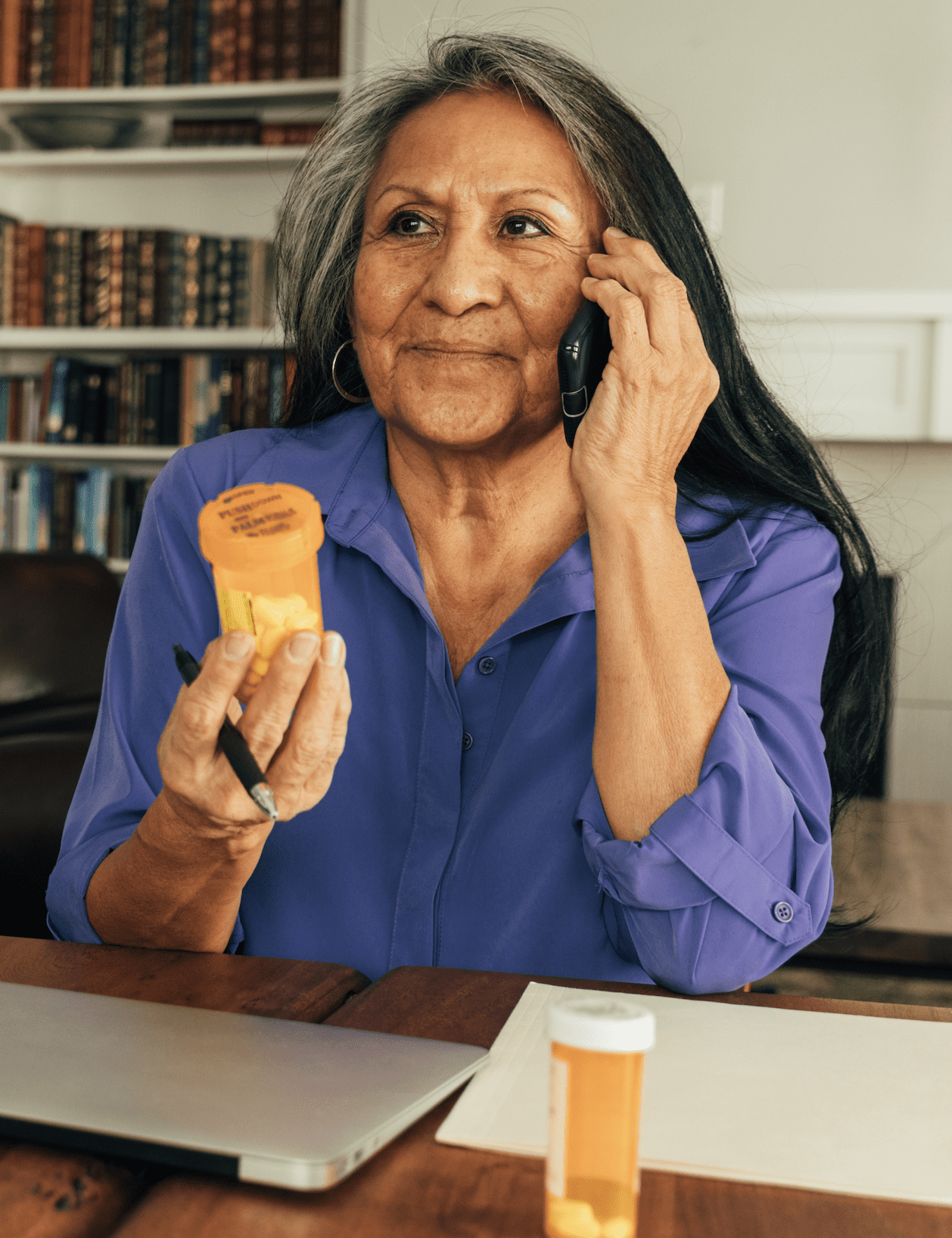a person holding a prescription bottle and talking on a phone